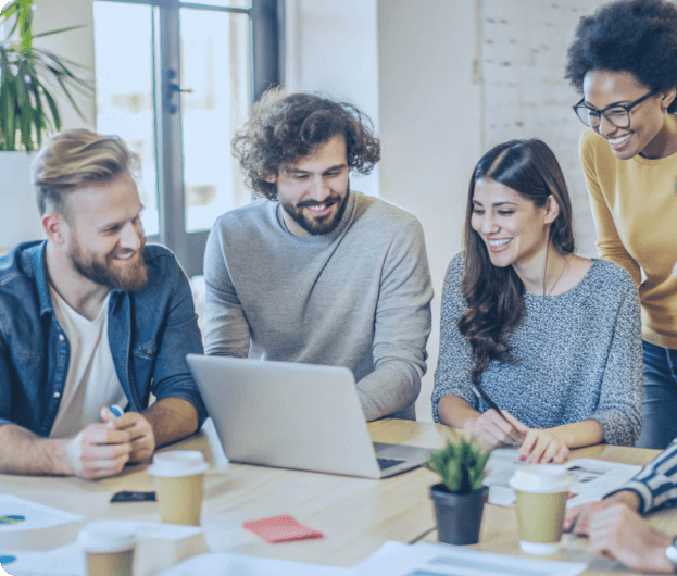 ludzie zgromadzeni w biurze wokół laptopa uśmiechają się przy tworzeniu strony internetowej